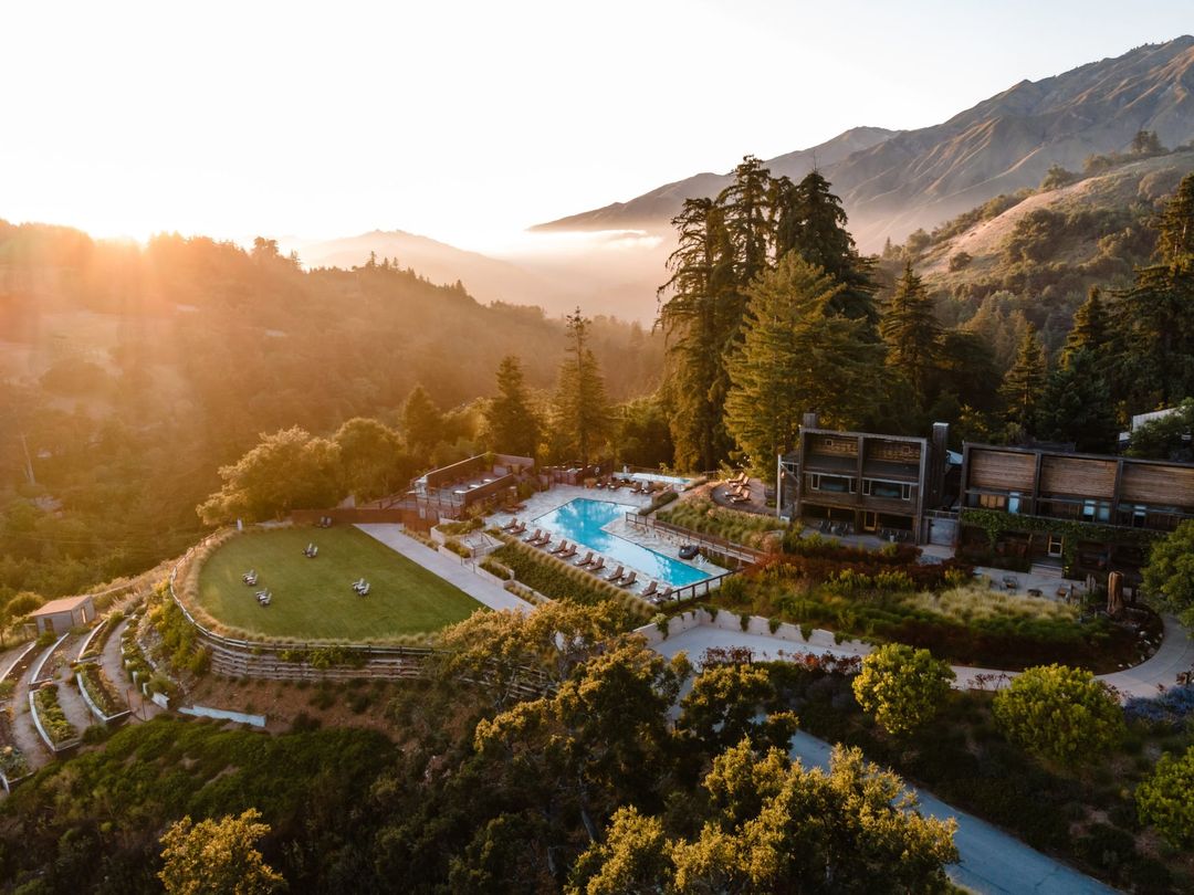 Alila Ventana Big Sur at sunset: the pool and timber lodges among redwoods on a ridge above the Big Sur coast