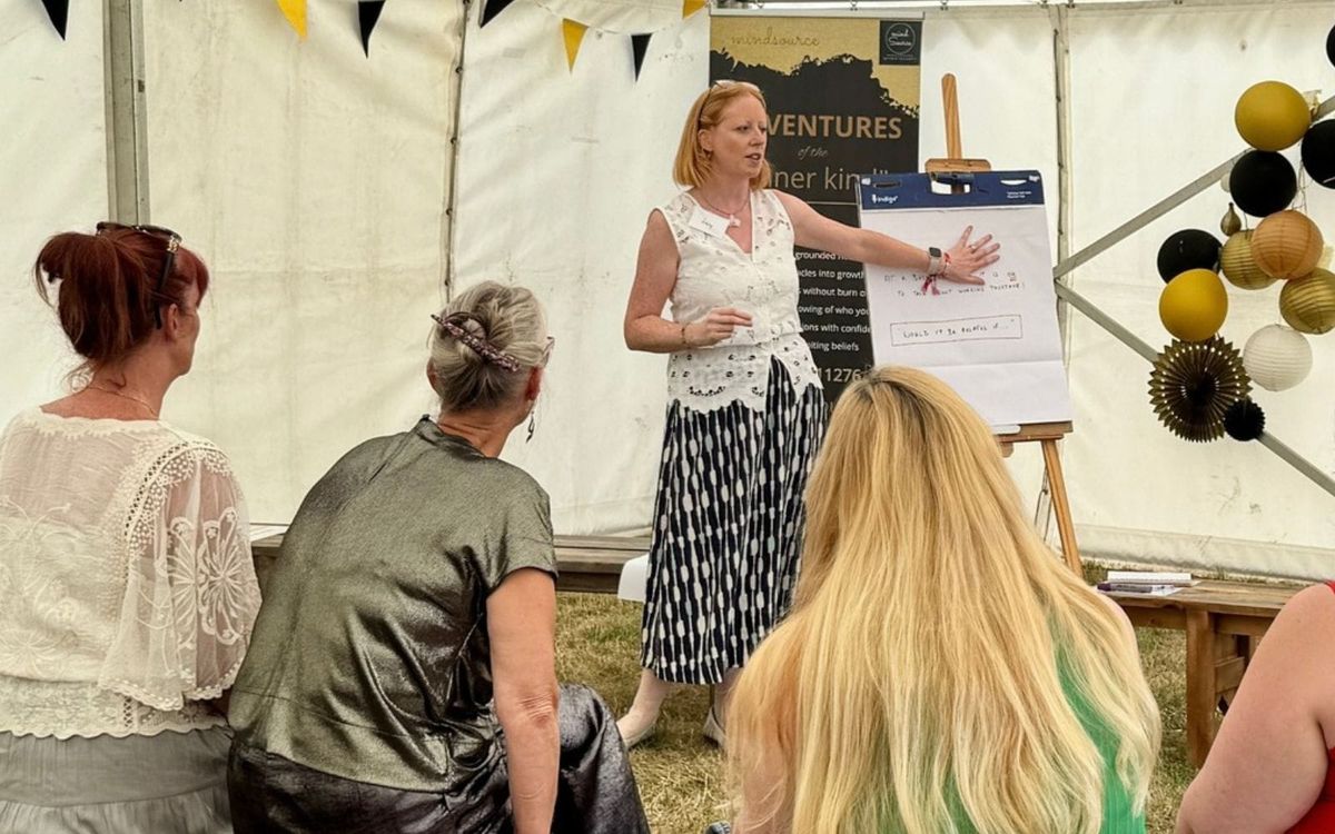 Lucy Davies, business coach, standing at a flipchart leading a workshop for a group of women in a marquee