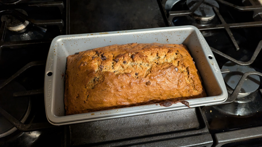 Banana bread coming out of the oven, sitting on top of the stove.