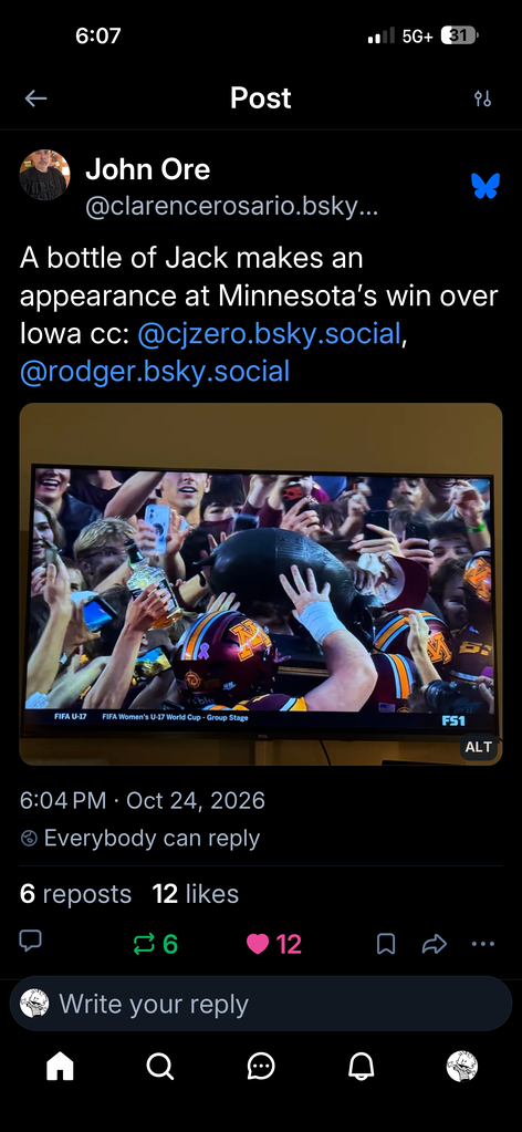 Screenshot of a bluesky post with text "A bottle of jack makes an appearance at Minnesota's win over Iowa", with a capture of Minnesota's players carrying Floyd of Rosedale.