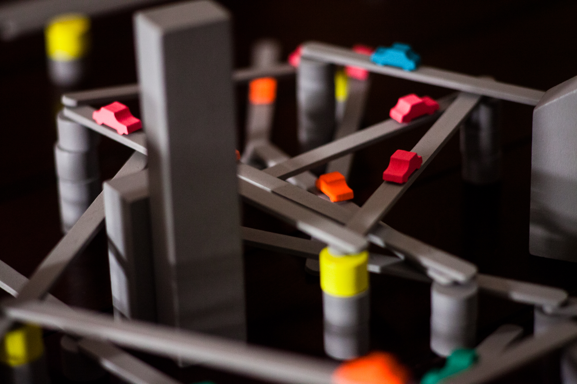 The board game Tokyo Highway on a table. Multiple highways are crossing over each other, and there are little car tokens on the highways.