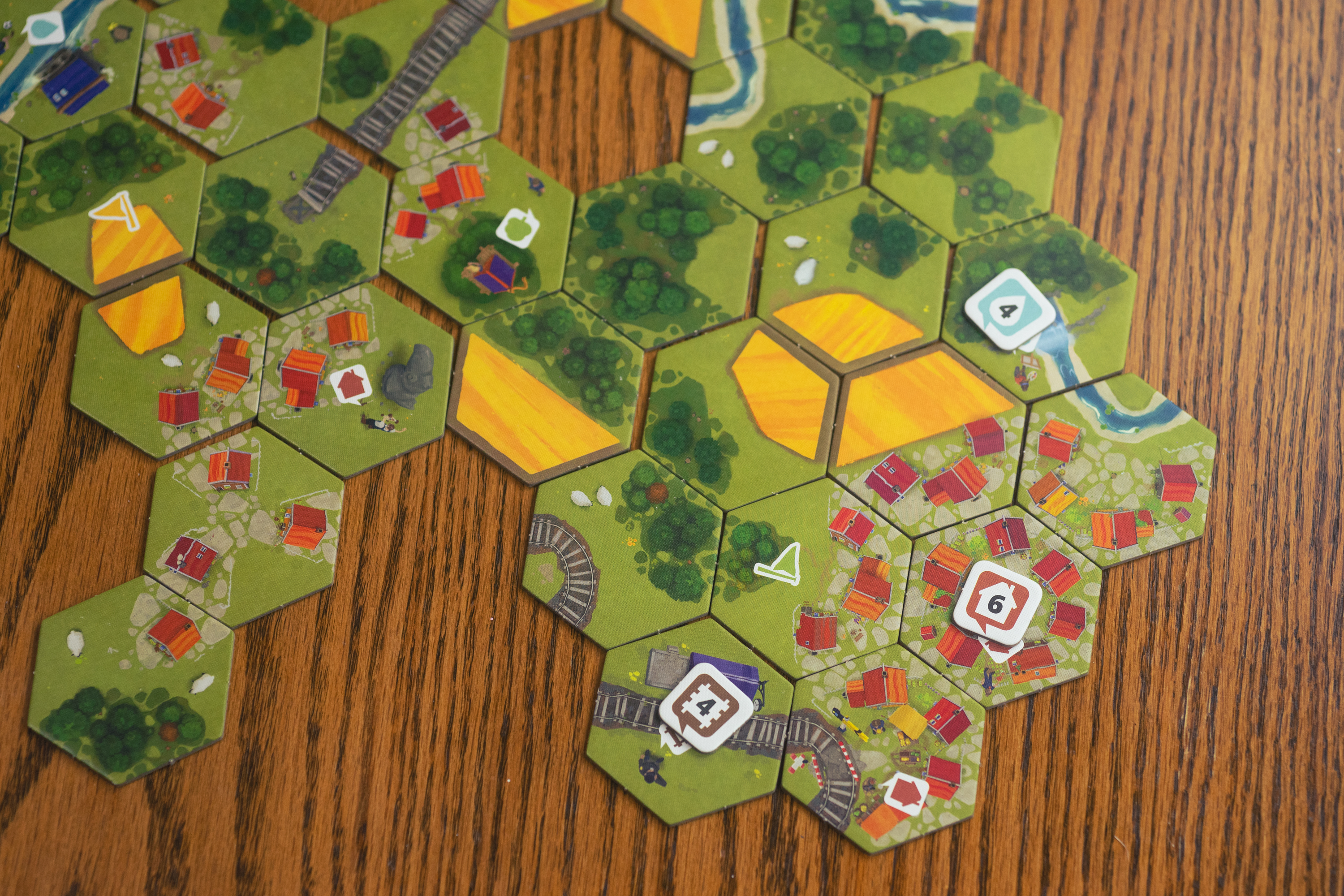 The board game Dorfromantik being played on a wooden table.