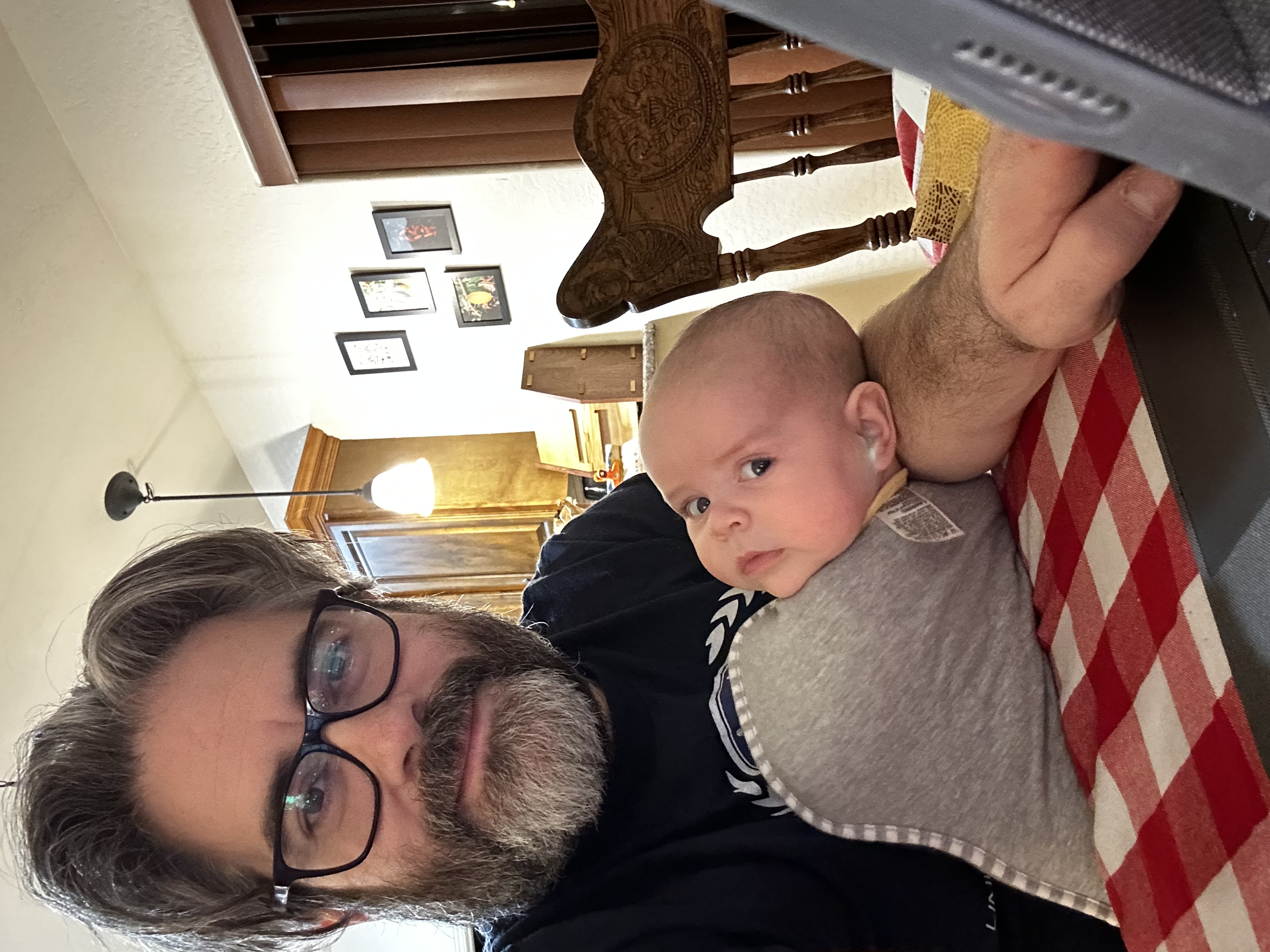 A photograph of me using my tablet while holding a baby, who is looking at the camera.