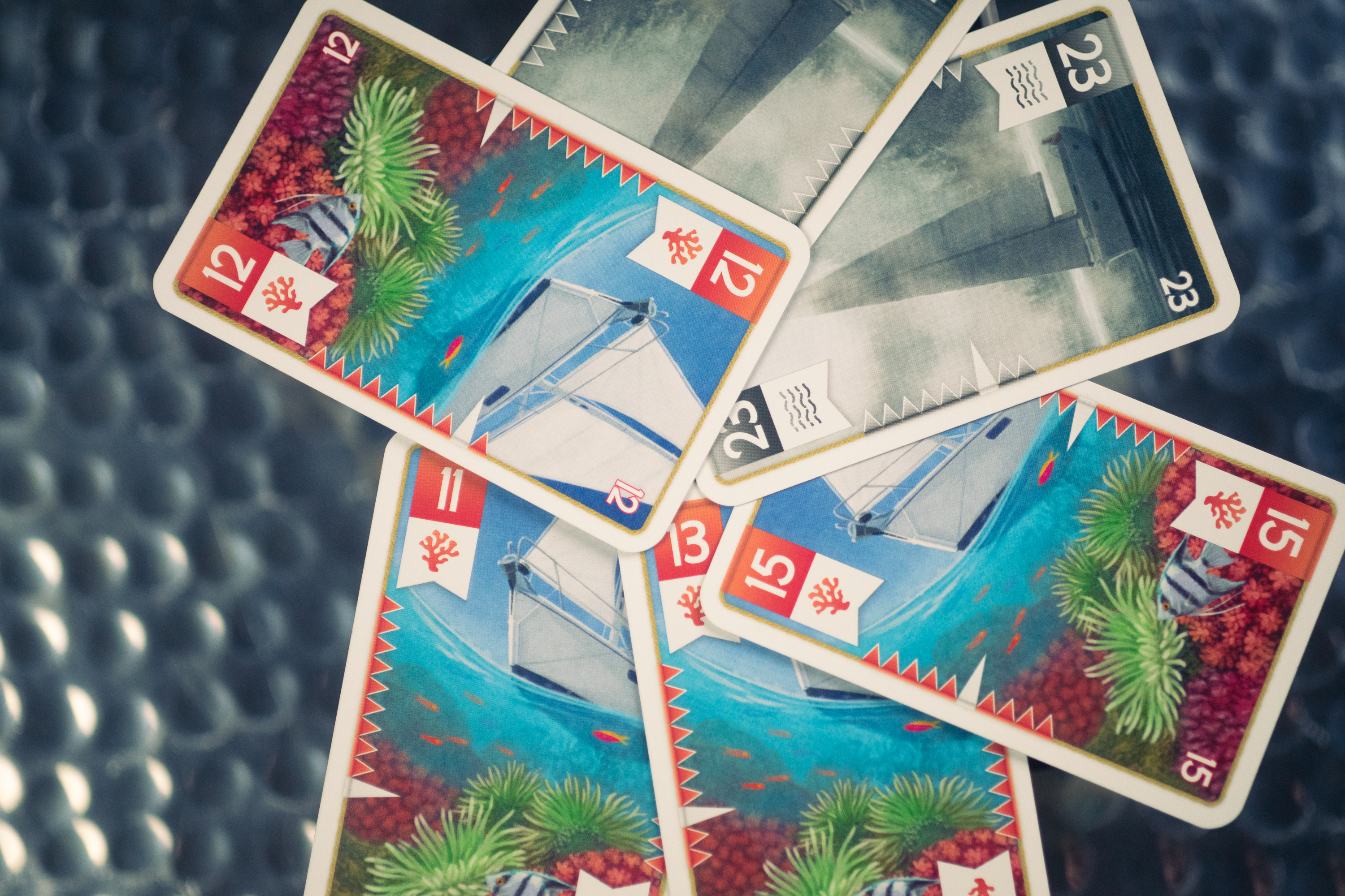 Cards from the game Seas of Strife displayed above a brushed metal surface.