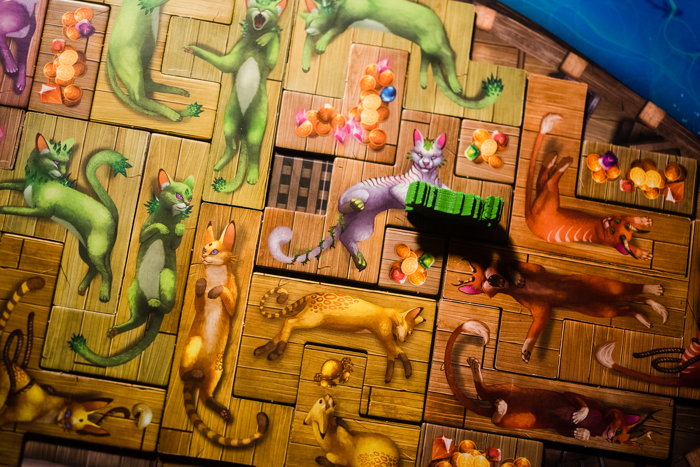 Polyomino cat tails placed on a board depicting a ship in the board game The Isle of Cats.