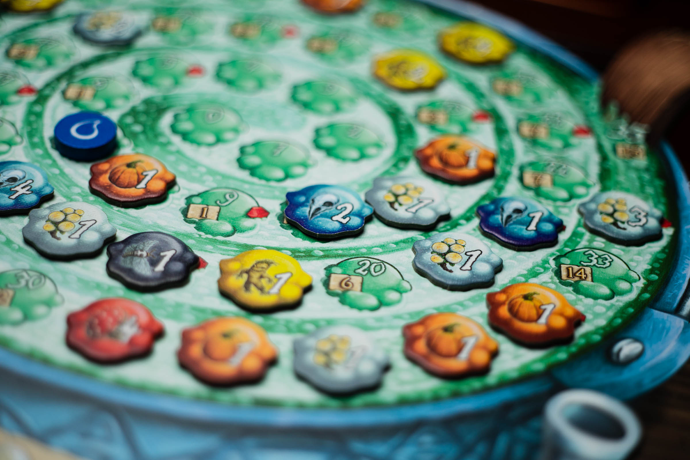 A player's cauldron in The Quacks of Quedlinburg. There are pumpkin tokens, cherry bombs, mandrake roots, and more on the board.