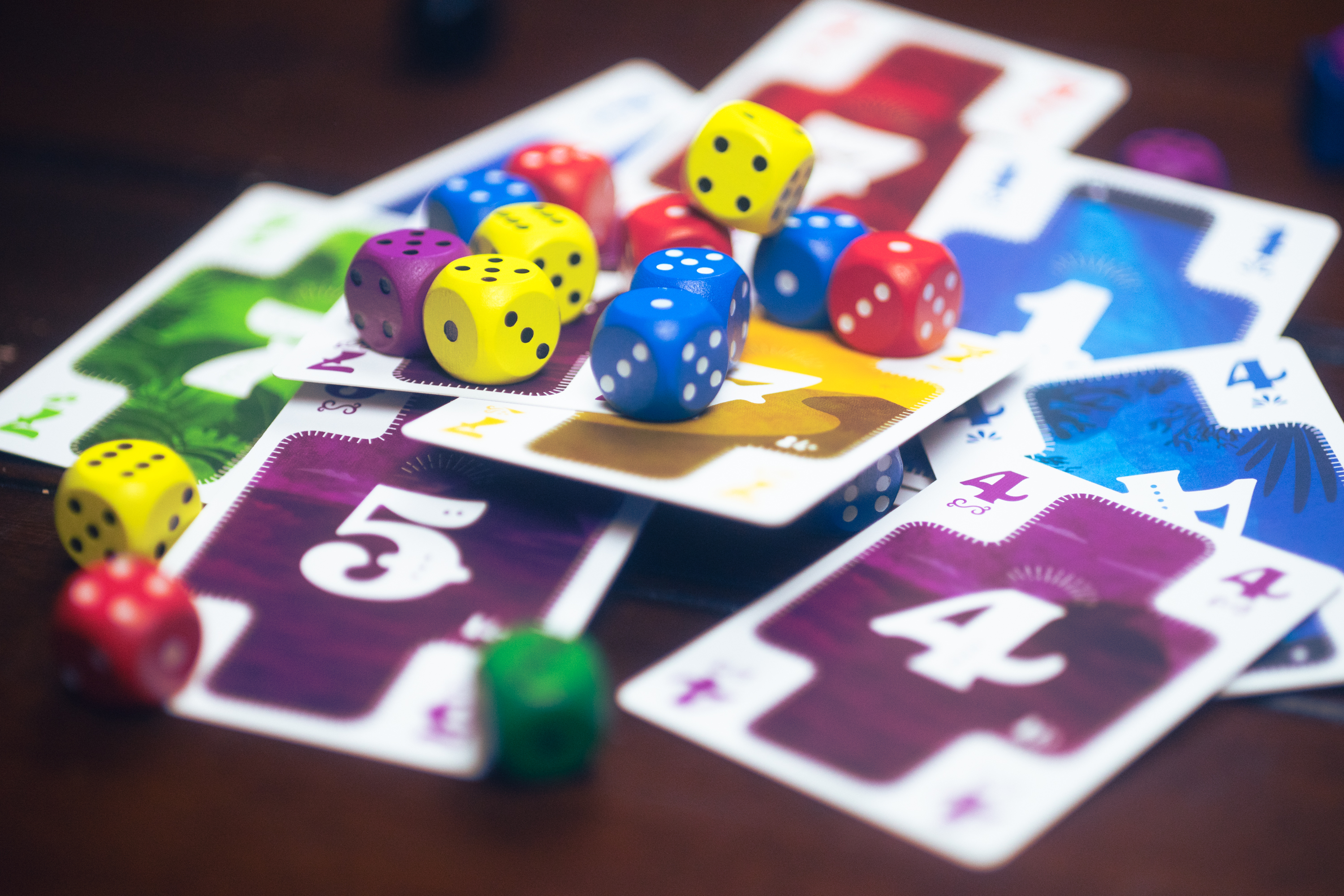 Cards and dice from the game Nokosu Dice on a table.