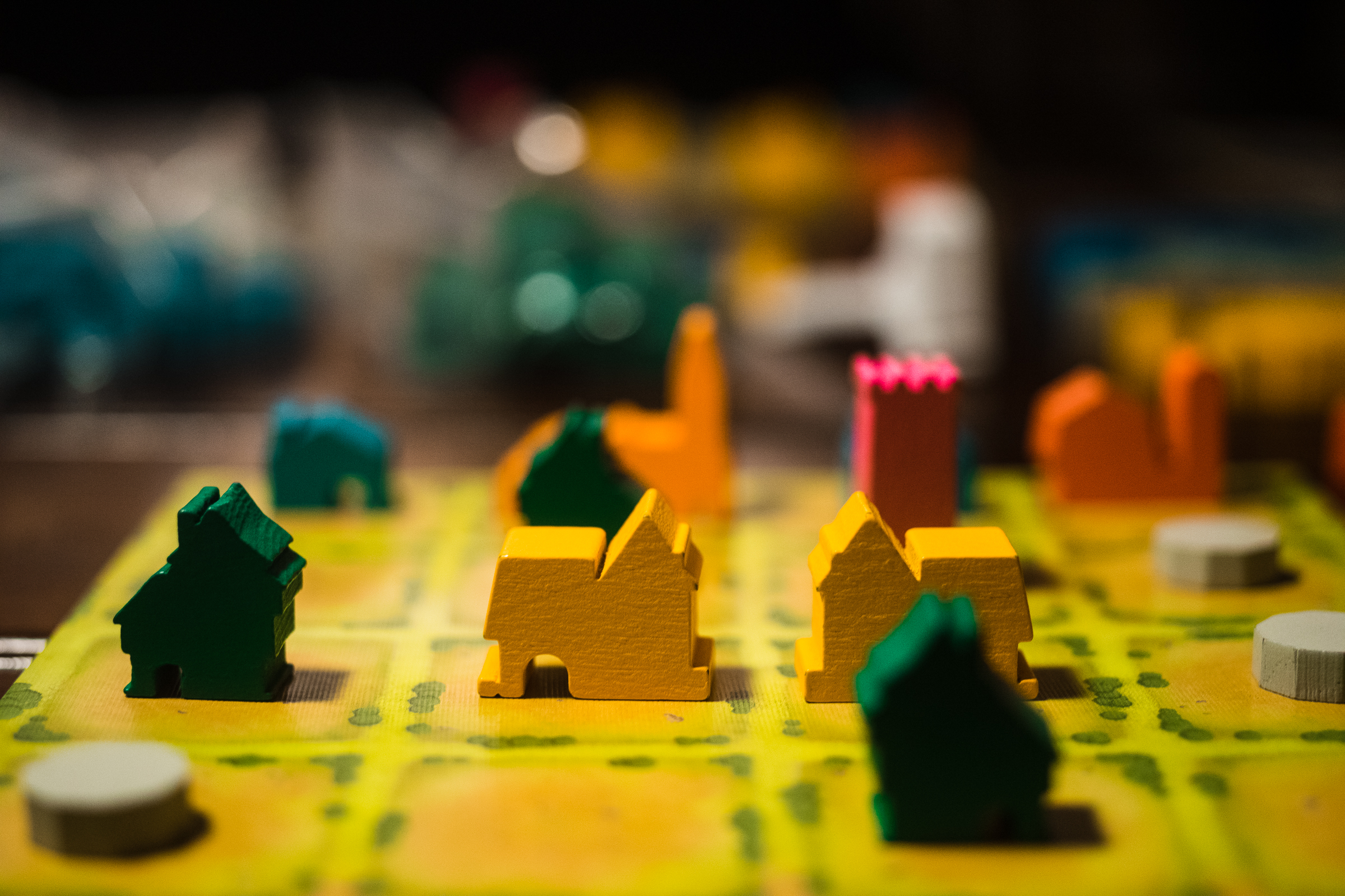 Tokens from the board game Tiny Towns on a board.