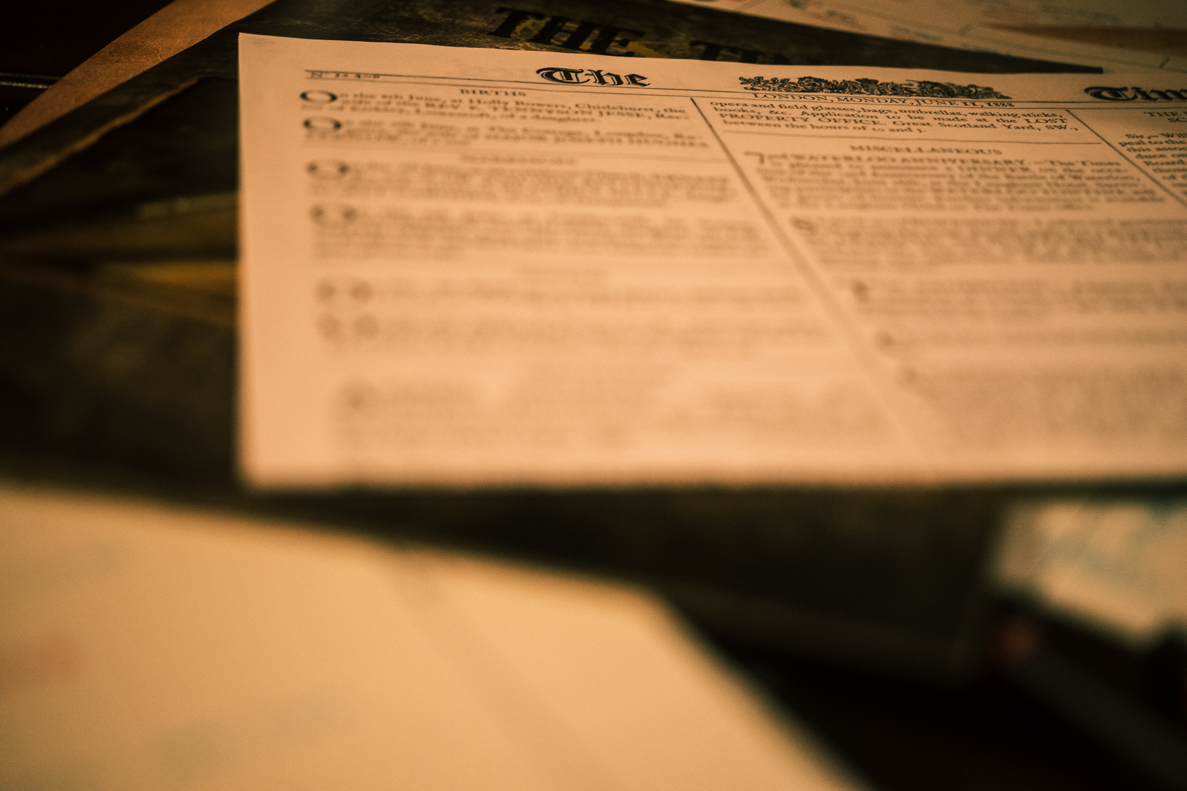 A fictional newspaper from the board game Sherlock Holmes Consulting Detective atop a table.