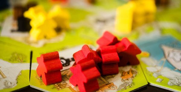 Workers from the game Keyflower pictured on the hex game board.