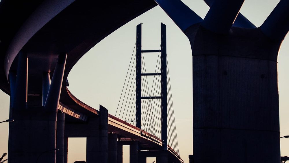 Modern bridge architecture illustrating the safe, transparent passage of tokenized information through a unified payment stack.