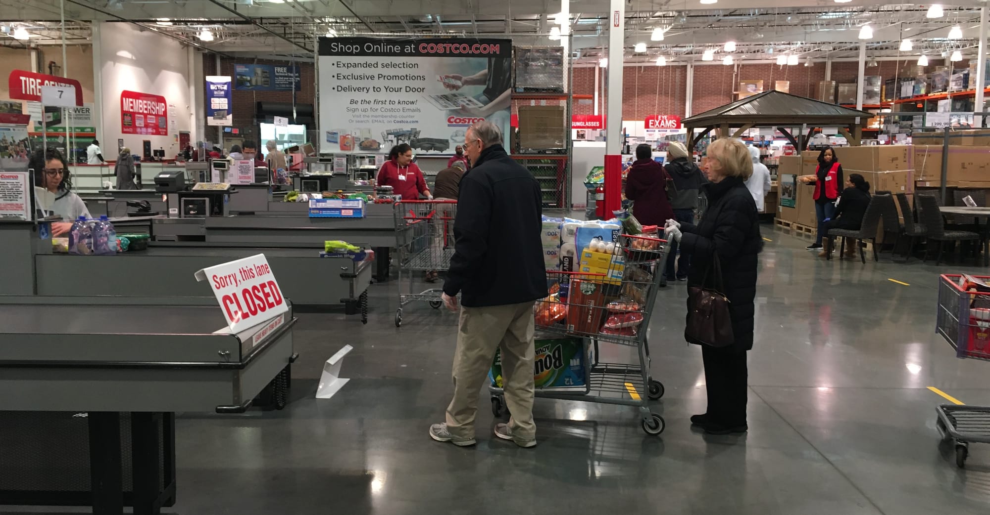 Shoppers with carts wait at open checkout lanes inside a Costco warehouse in North Brunswick, New Jersey, during 2020 social-distancing measures.