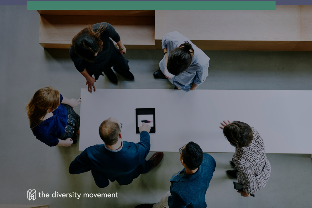 Overhead view of six people standing around a conference table