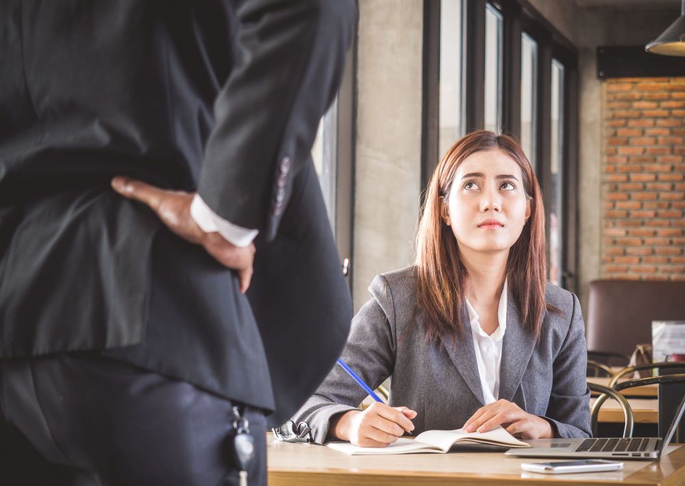 Aggressive boss complaining to Asian business woman in office