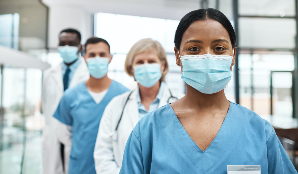 Portrait of a group of medical practitioners wearing face masks while standing together in a hospital