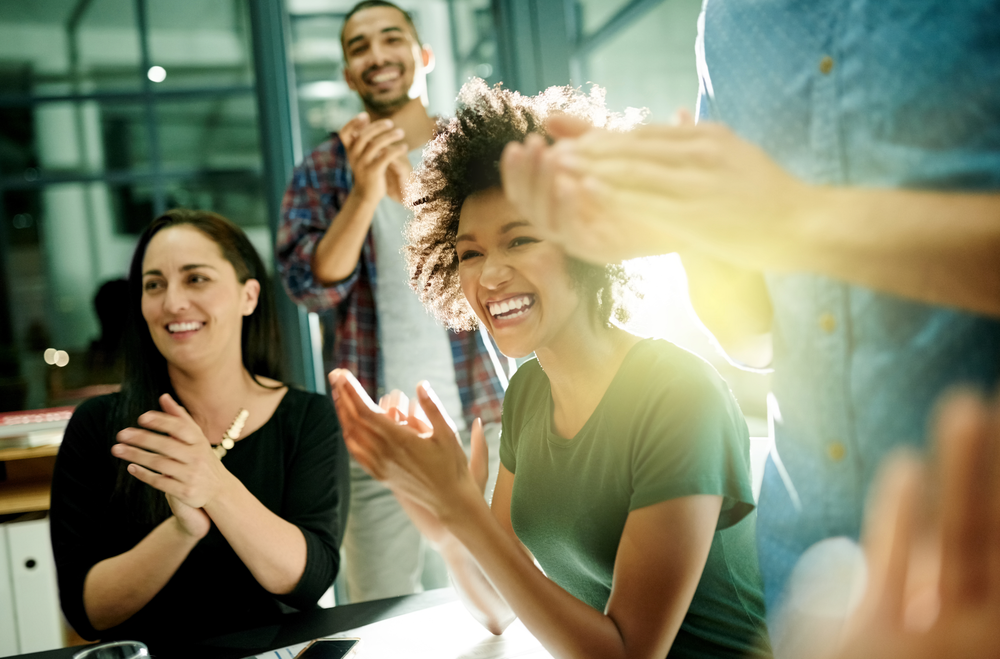 Shot of a team of creative businesspeople applauding an achievement while working late in the boardroom