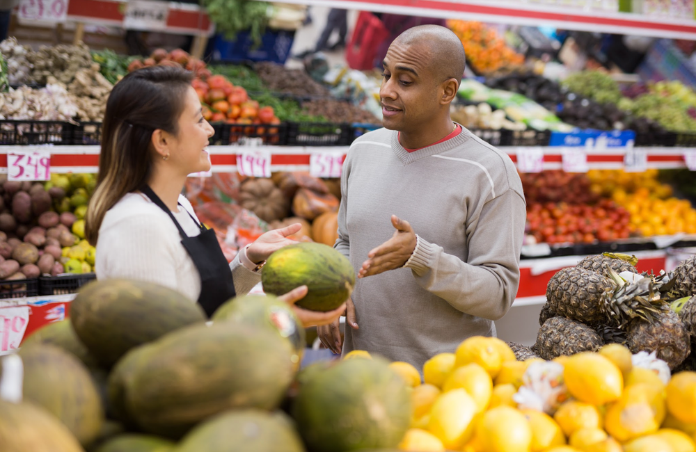 Employee helping customer in grocery store
