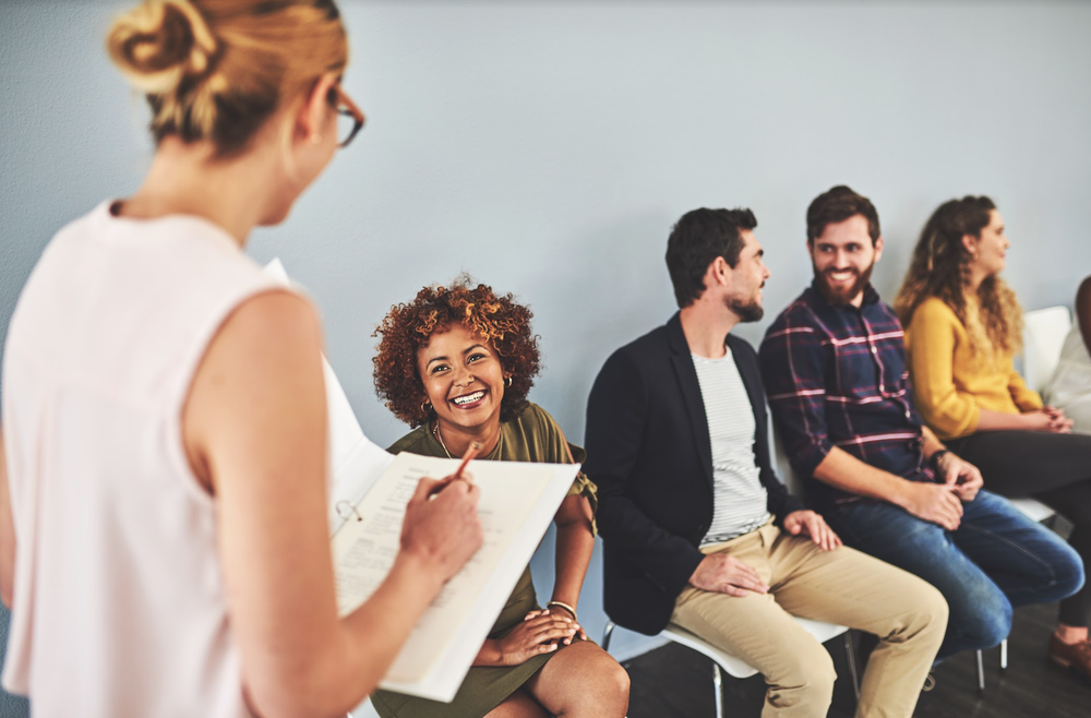 Stock image of woman calling in a job seeker from a row of job seekers