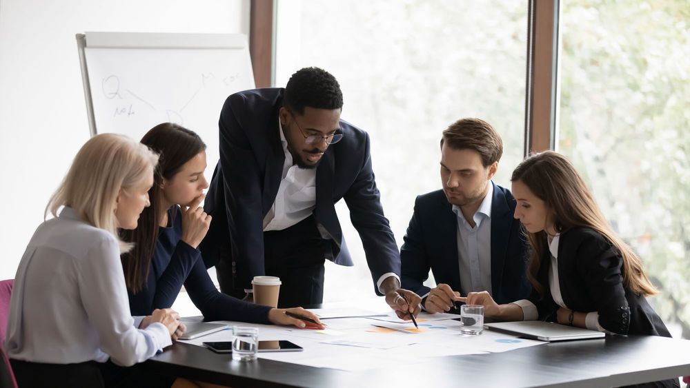 Confident Black man leading a team in an office
