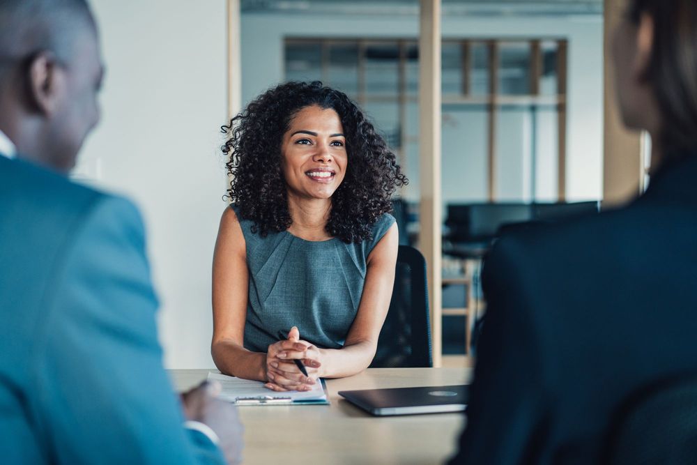 Woman of color in professional dress with black curly hair