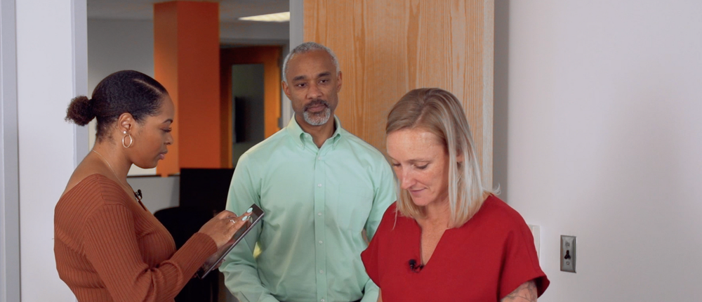 Three people in the doorway of an office