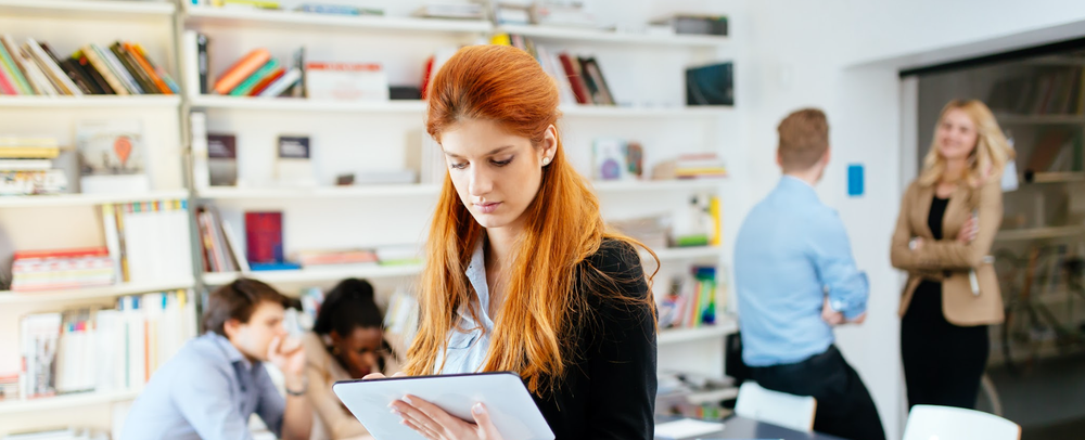 Woman looking at a tablet in an office break room