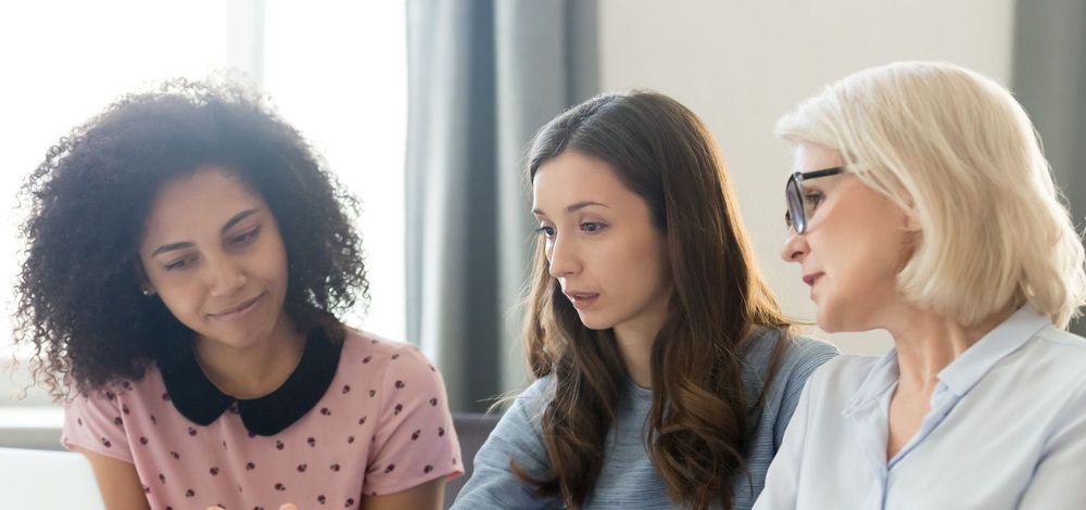 Three women of diverse ages in an office