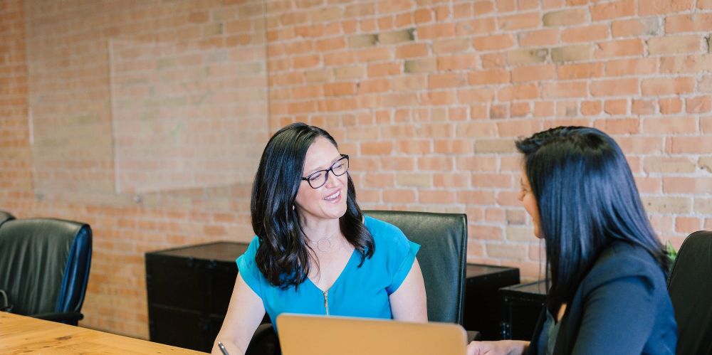 Two people talking at a conference table