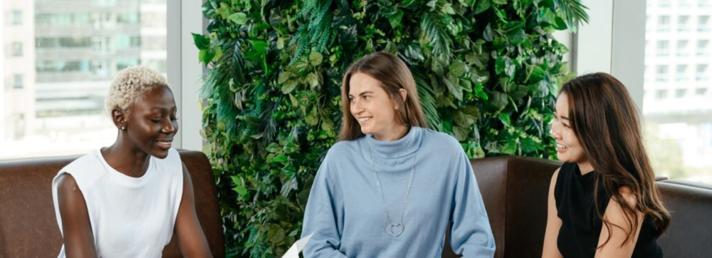 Three women sitting on a couch collaborating