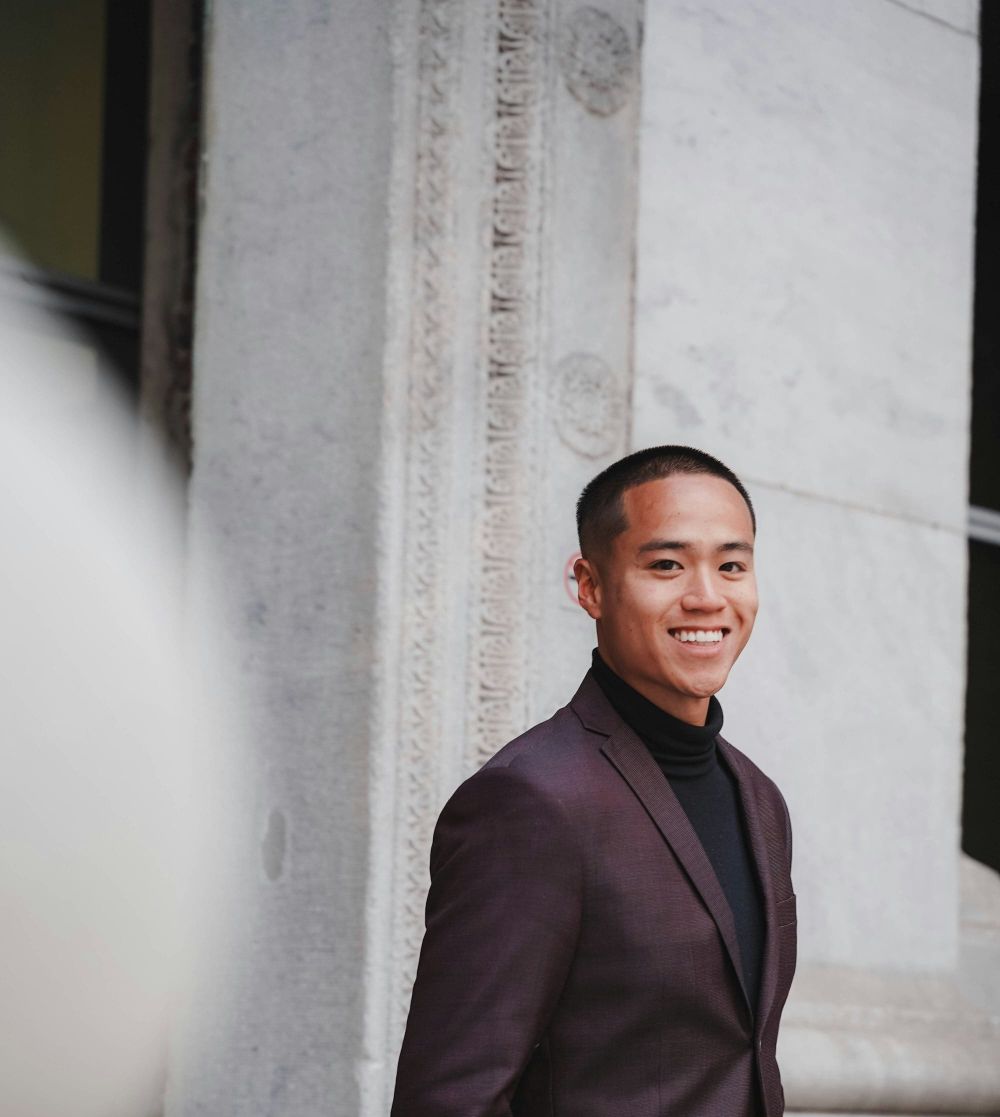 Headshot of a man in a plum suit