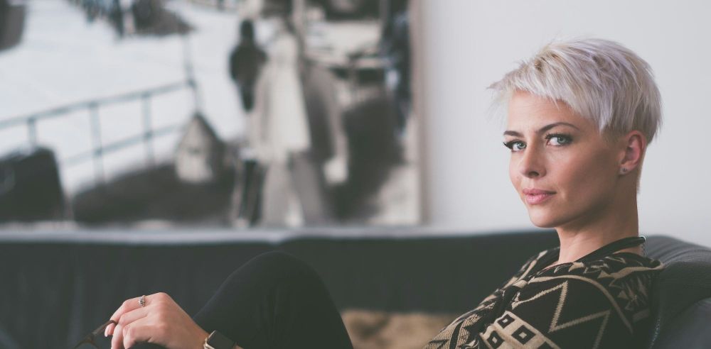 White woman with blond hair on a couch