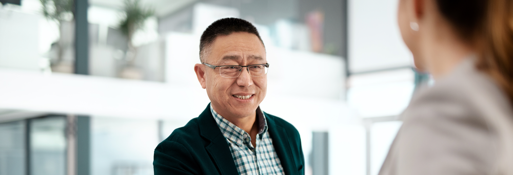 Shot of an older businessman and businesswoman shaking hands in a modern office
