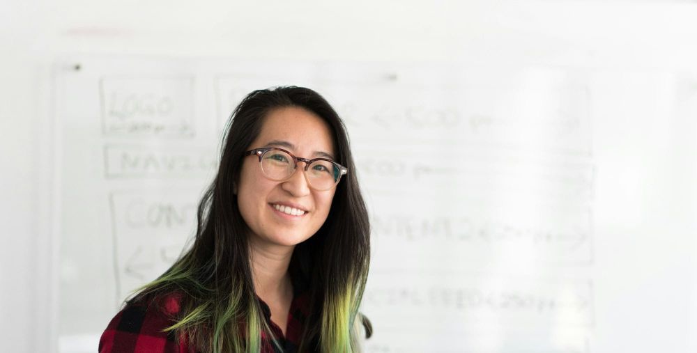 Person of Asian descent in front of a white board