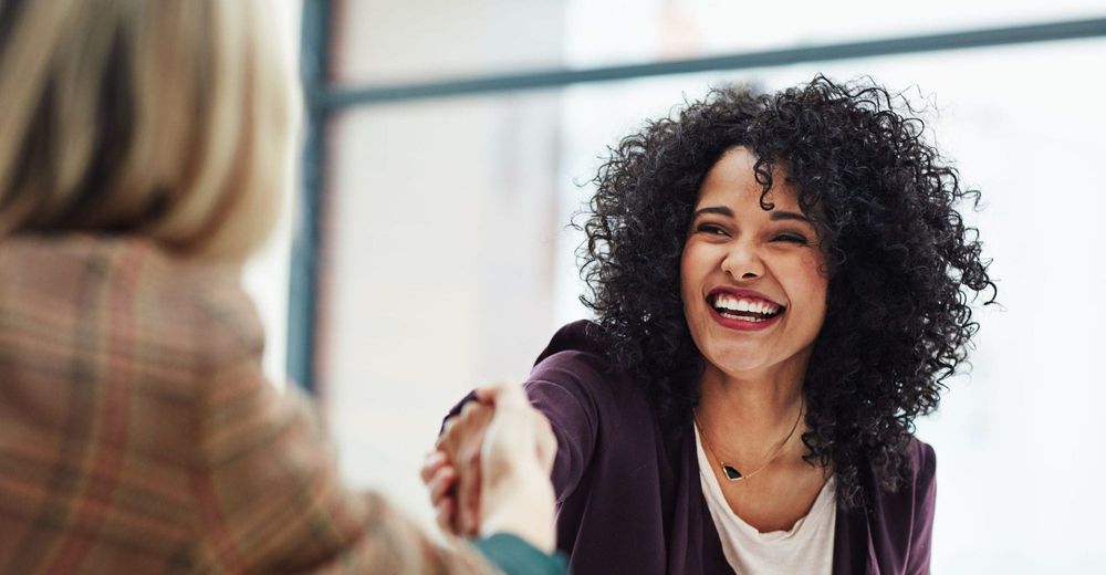 Shot of two colleagues shaking hands during a meeting at work