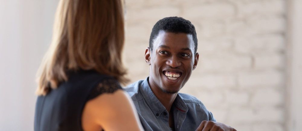 Black man and white woman talking.