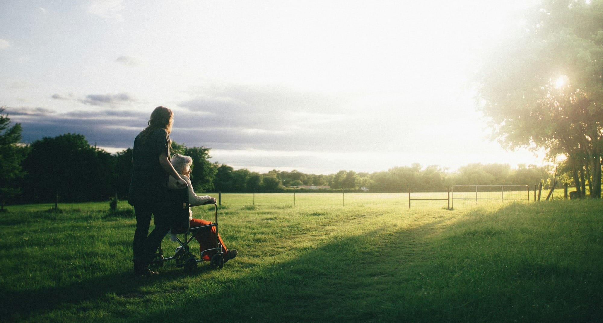 woman standing next to woman riding wheelchair