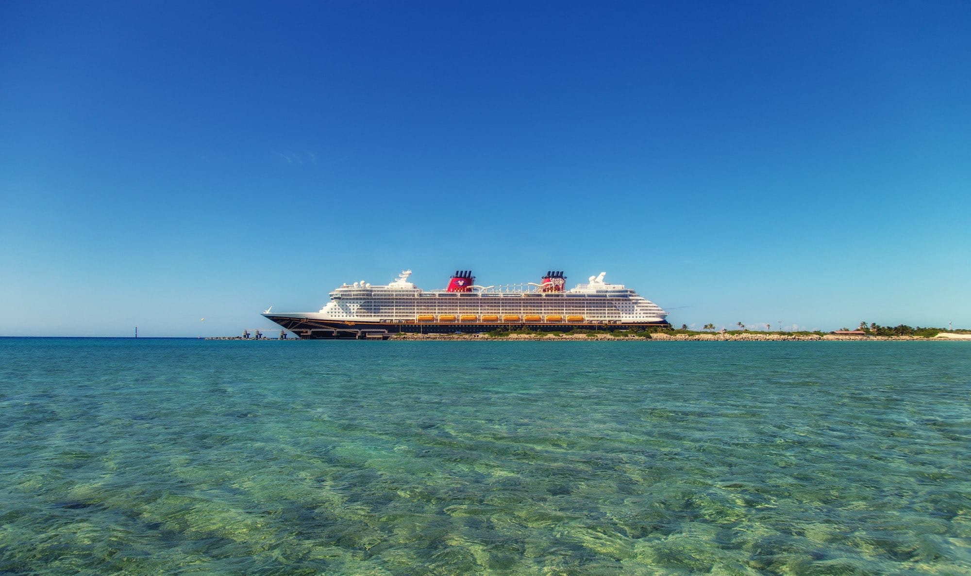 white and black cruise ship on water under the blue sky during daytime