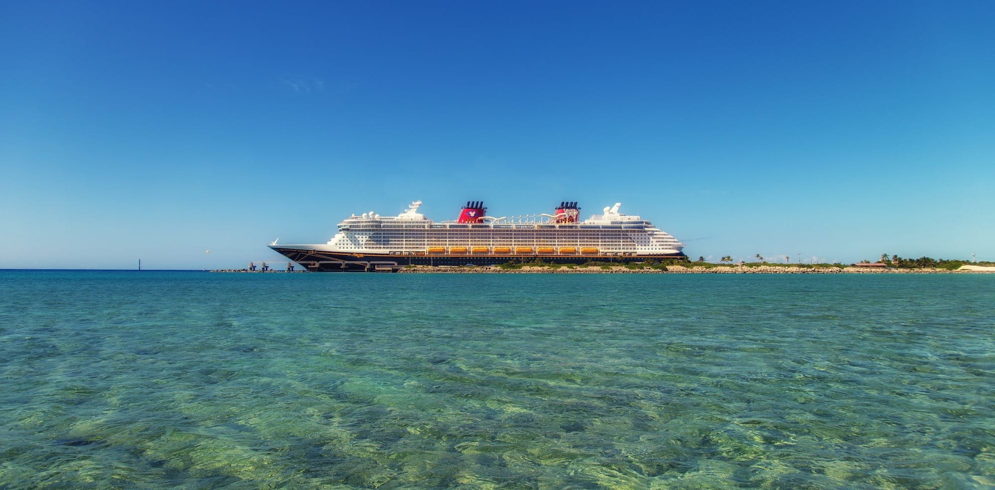 white and black cruise ship on water under the blue sky during daytime