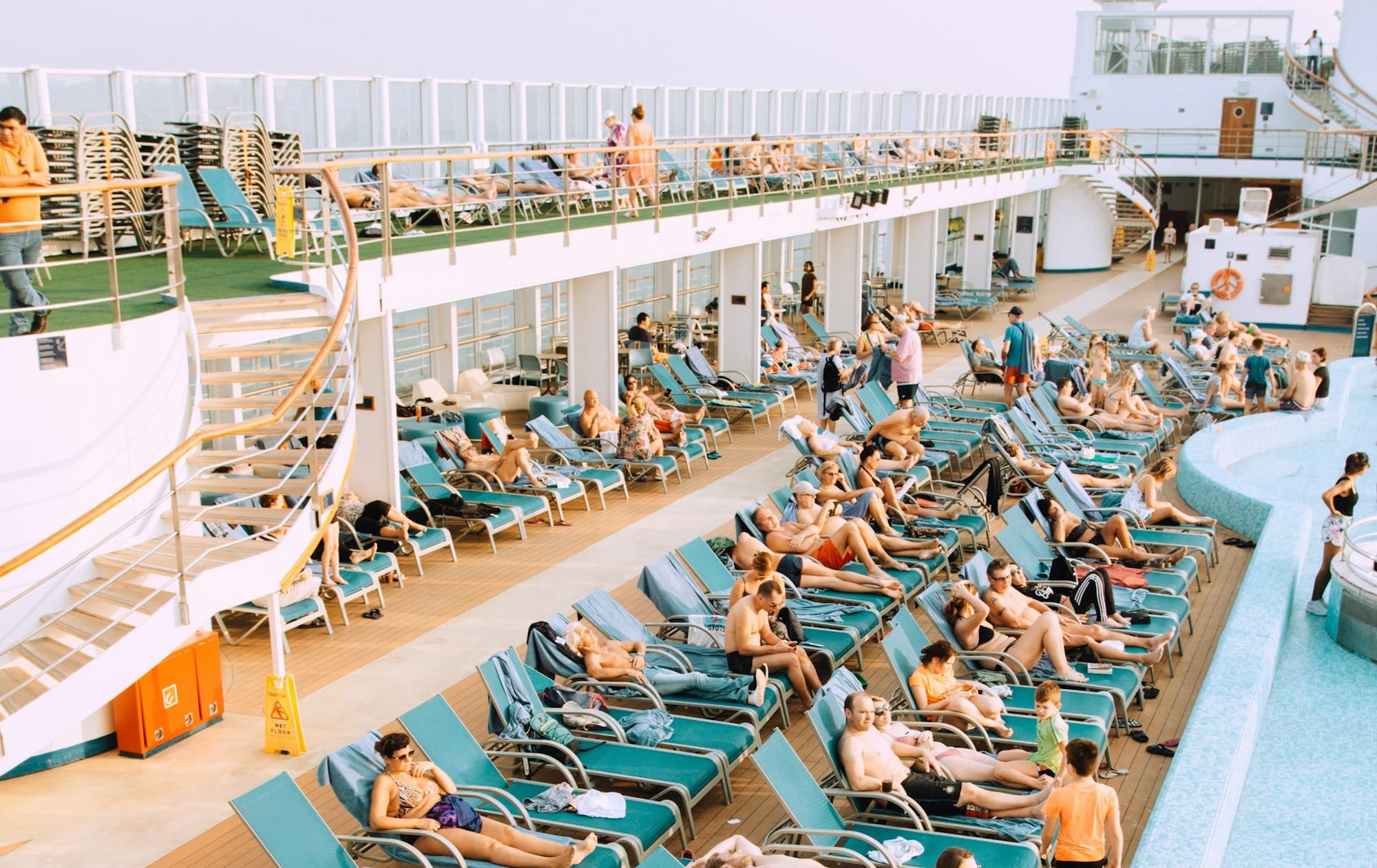 people lying on blue and white lounge chairs