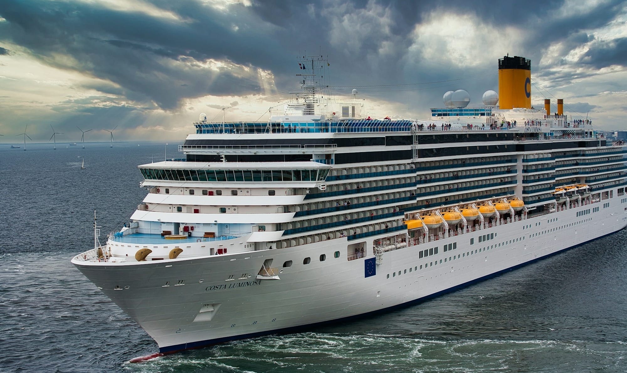 white cruise ship on sea under white clouds and blue sky during daytime