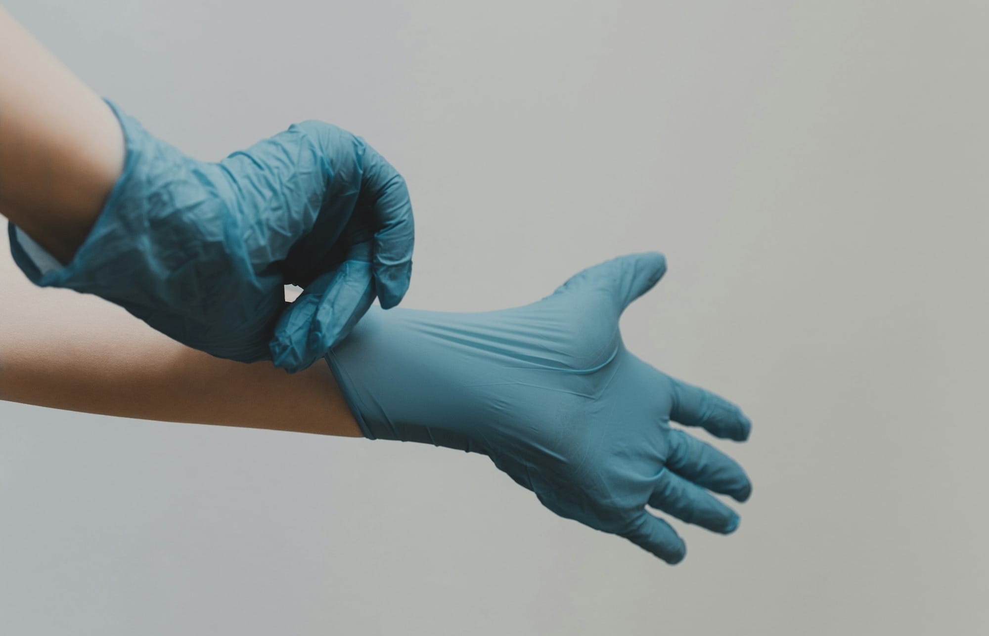 person in blue gloves and blue denim jeans