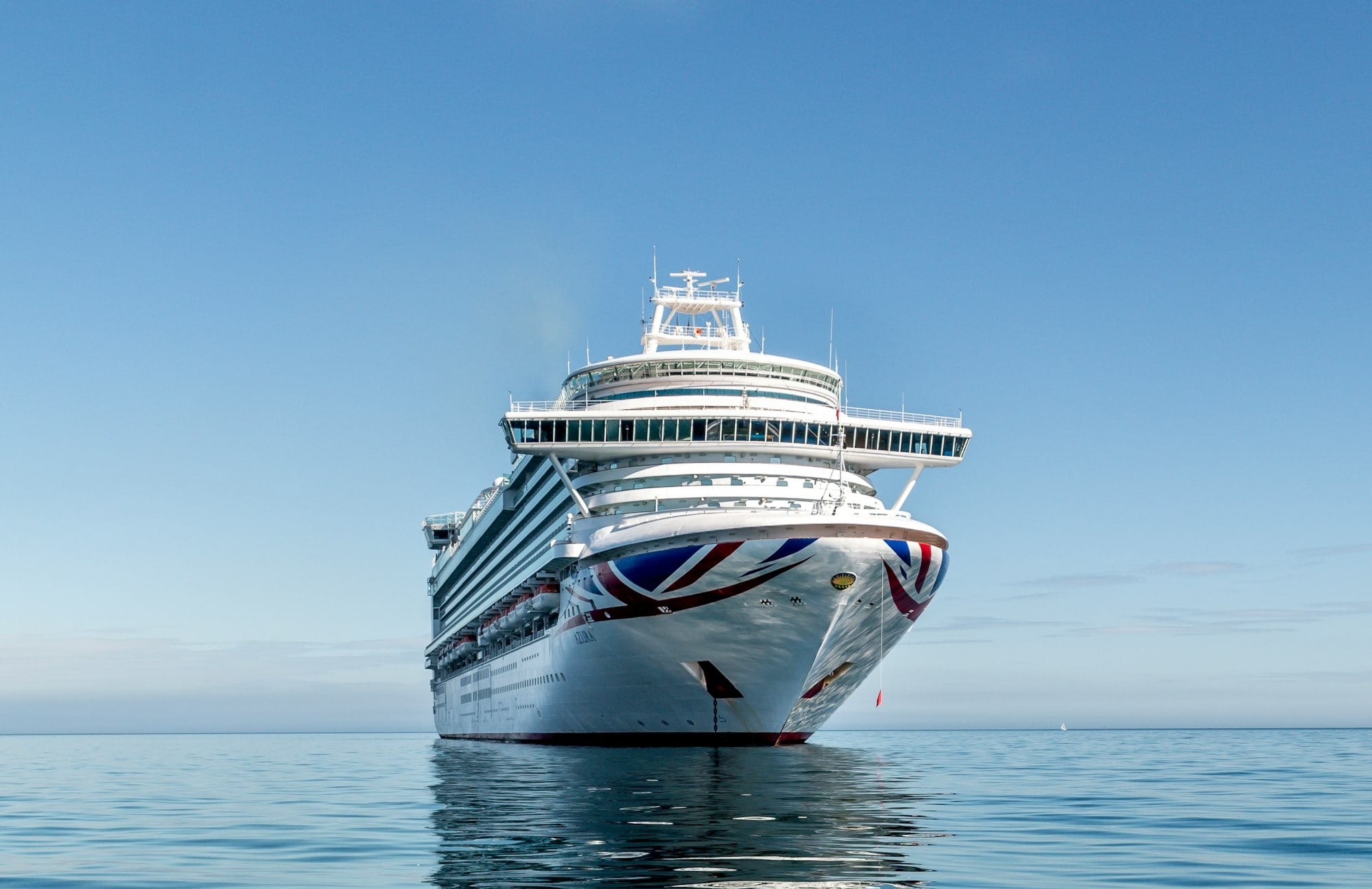 white and blue boat on sea under blue sky during daytime