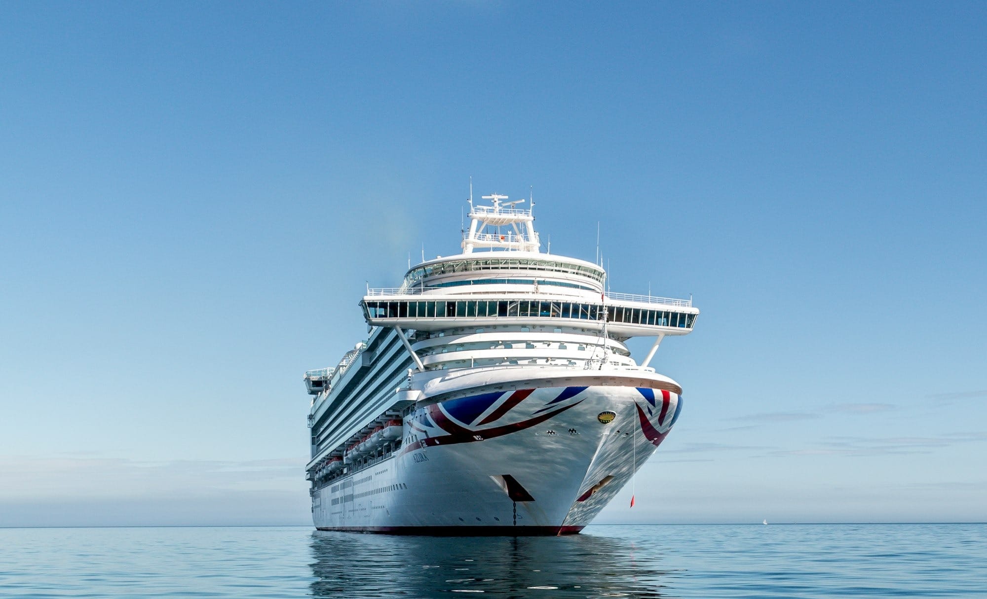 white and blue boat on sea under blue sky during daytime