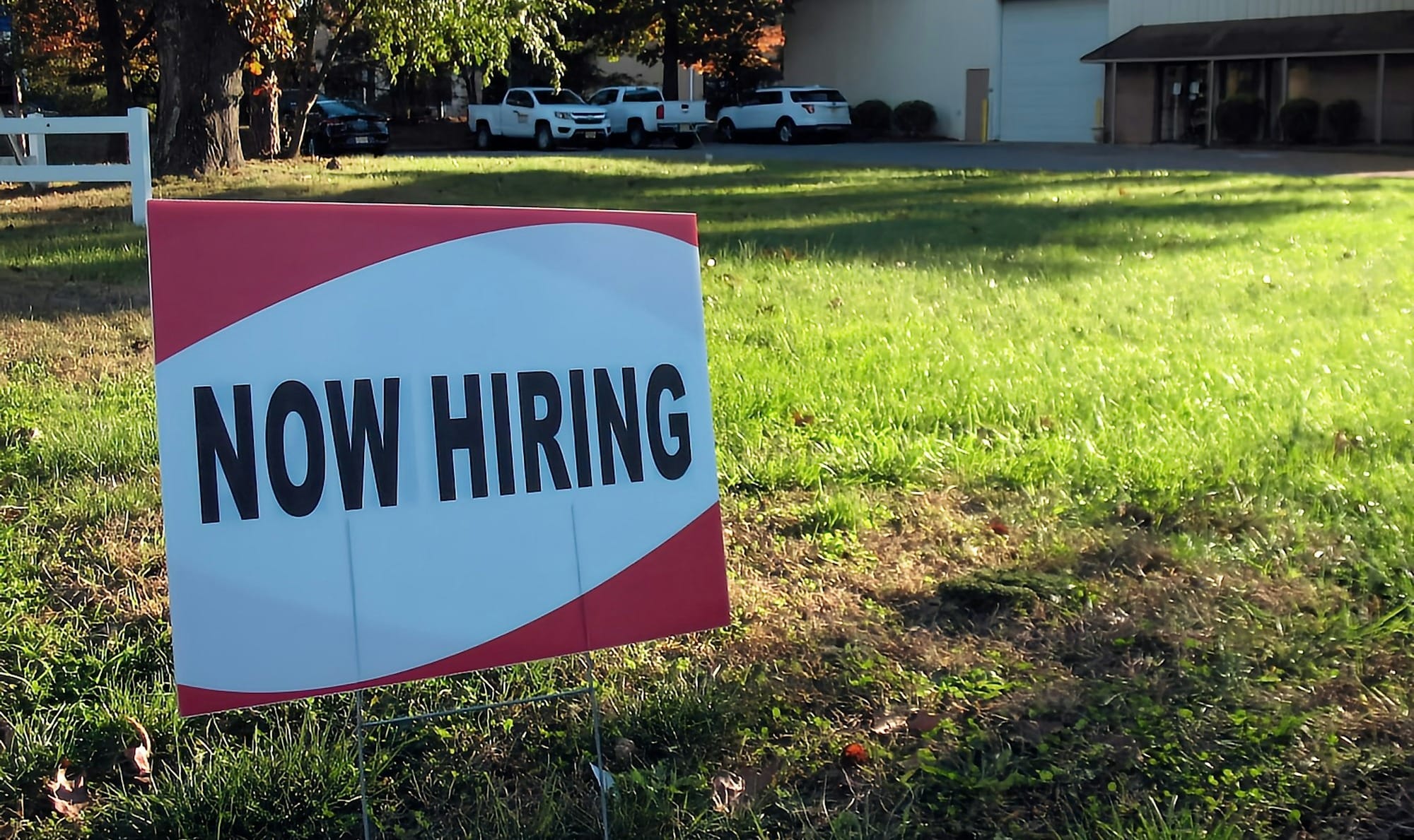 a now hiring sign in front of a building