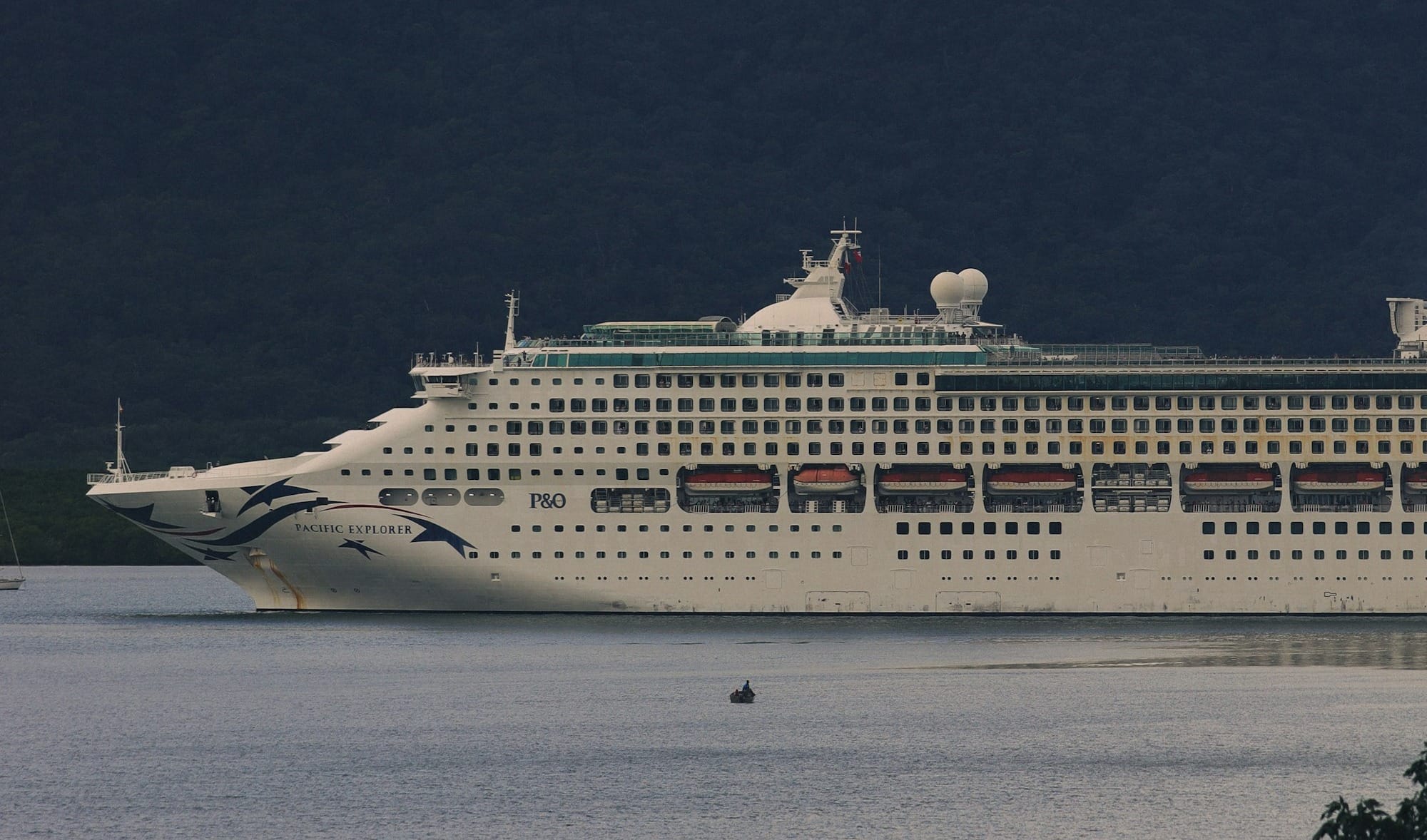 A cruise ship with a rainbow in the background