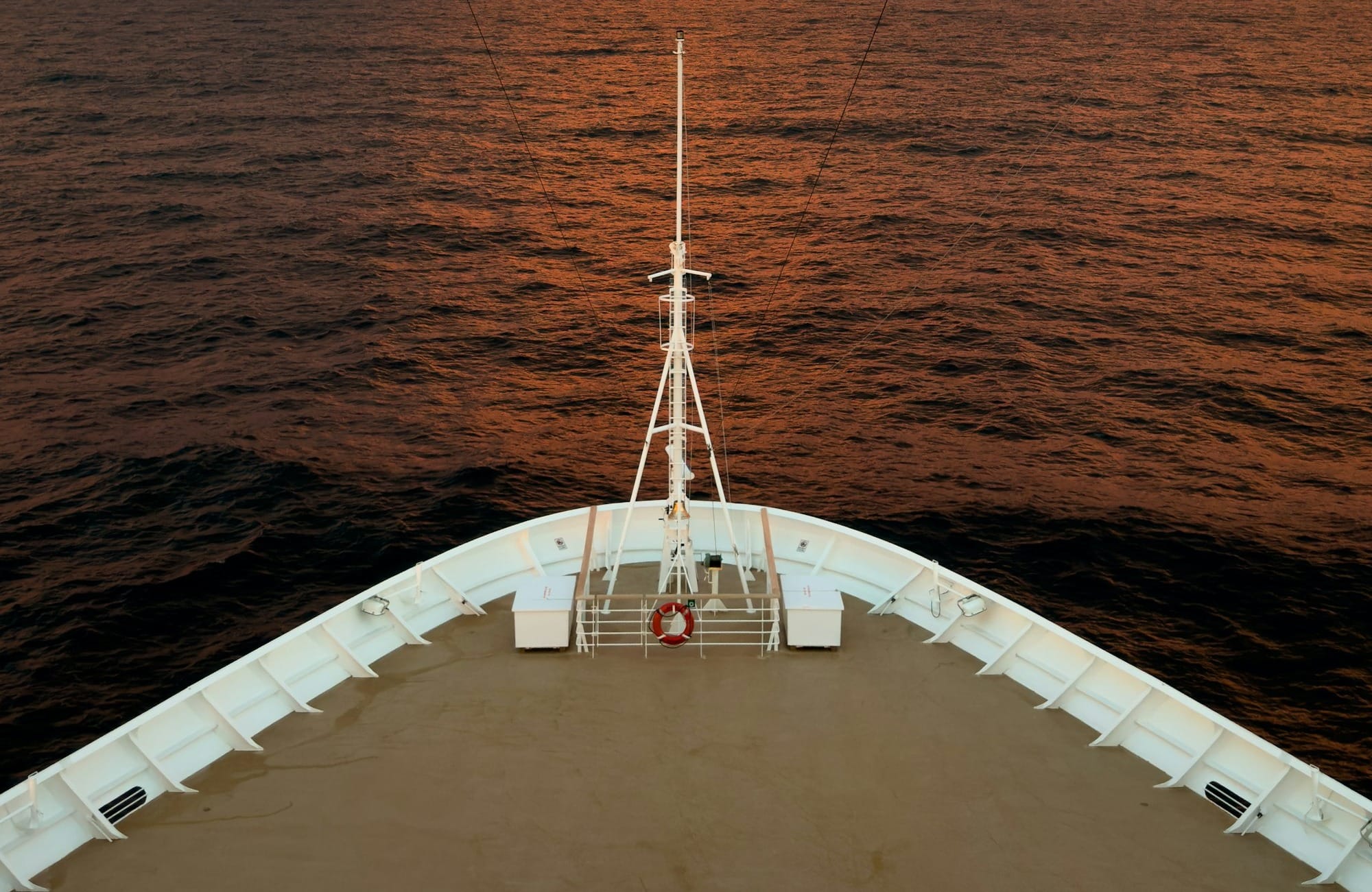 A boat traveling across a large body of water under a cloudy sky