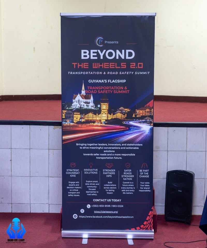 The Beyond The Wheels 2.0 banner at the Eve Leary ceremony, billing the Summit as Guyana's flagship transportation and road safety summit.