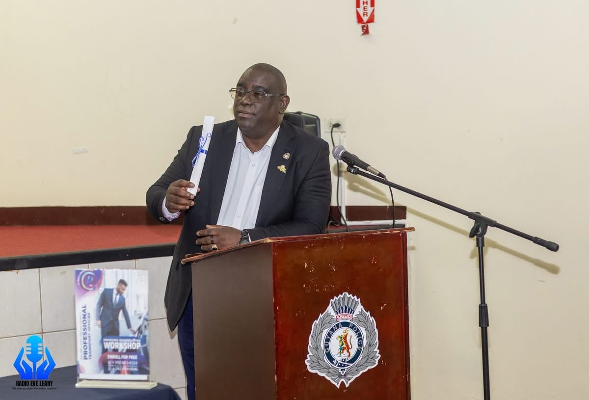 Adrian Clarke, Founder and Managing Director of Clarke's Productions Inc., at the podium during the certificate presentation. The standee at left advertises a free Professional Transport Officer workshop.