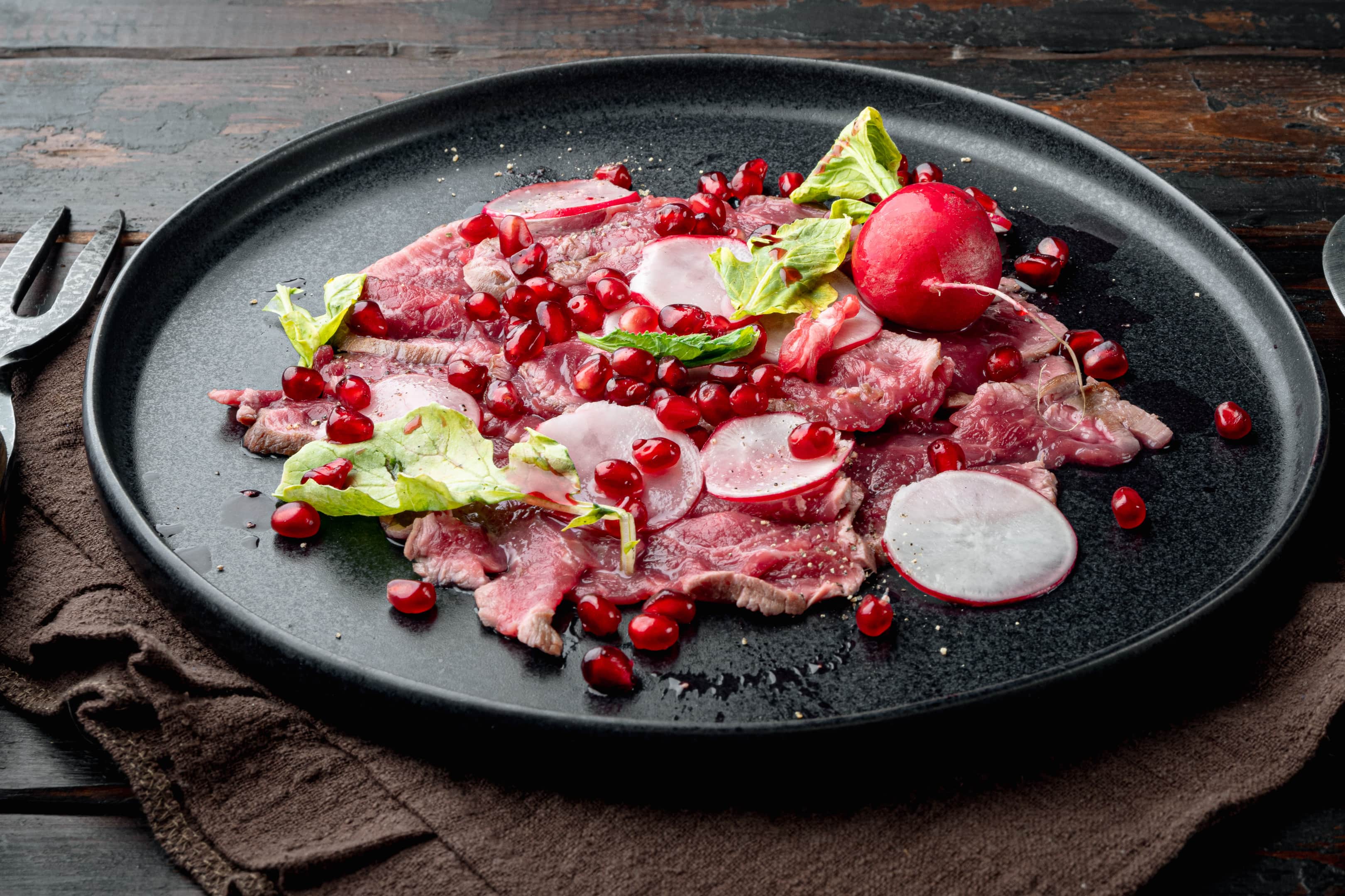 Beef carpaccio with radish, pomegranate seeds, olive oil and red wine vinegar