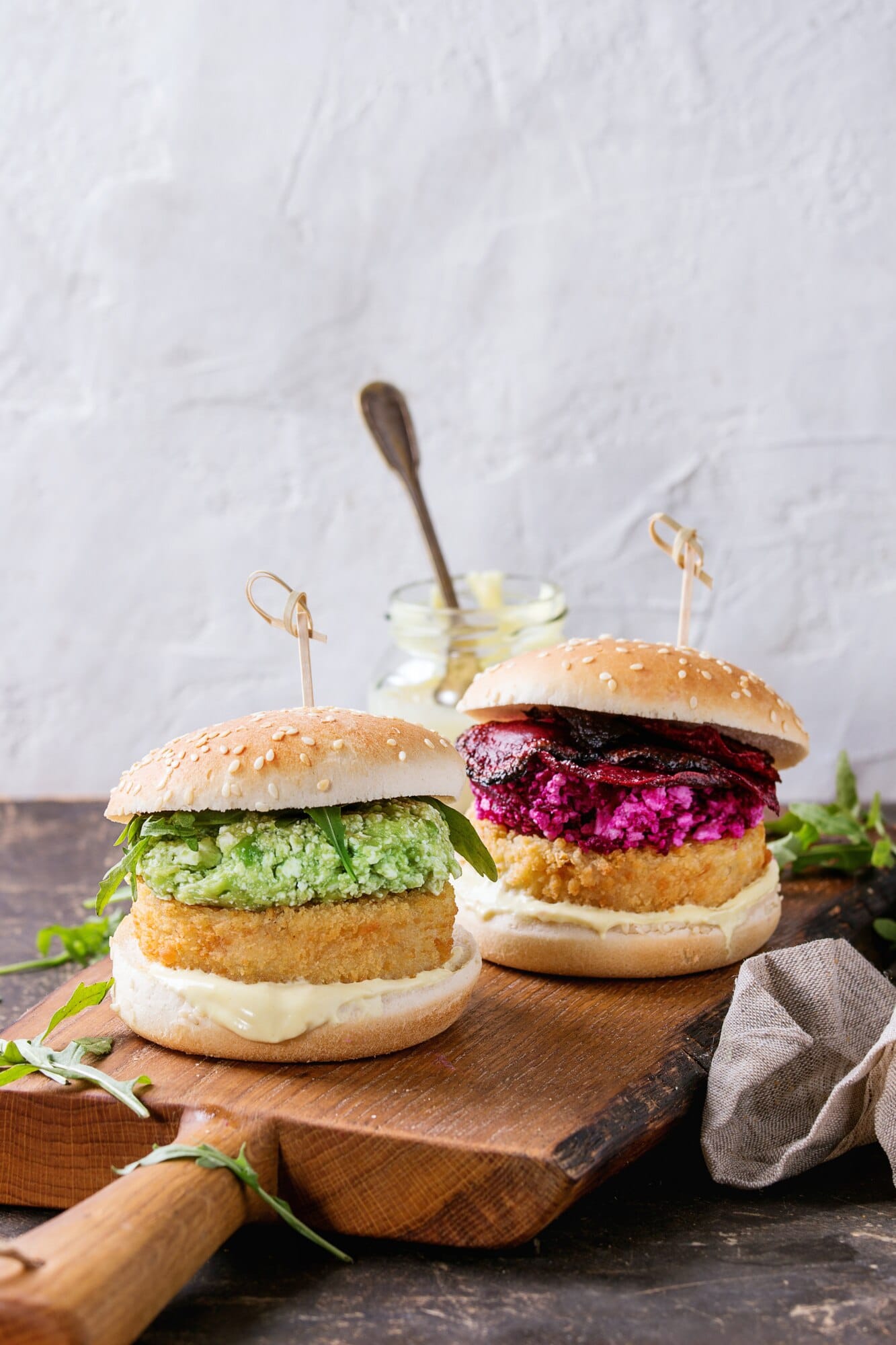 Vegan burgers on buns with avocado and beetroot toppings